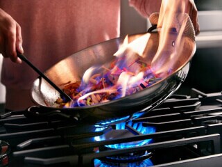 Person cooking on a gas cooktop