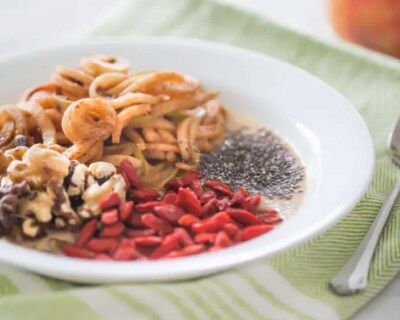 Apple pie smoothie bowl topped with apples noodles, walnuts, goji berries and chia seeds