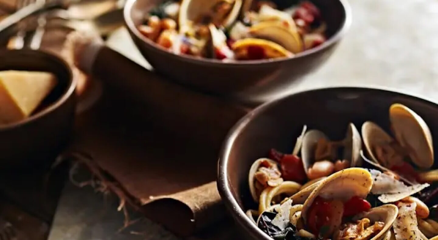 Bowls of steamed clams with beans and greens