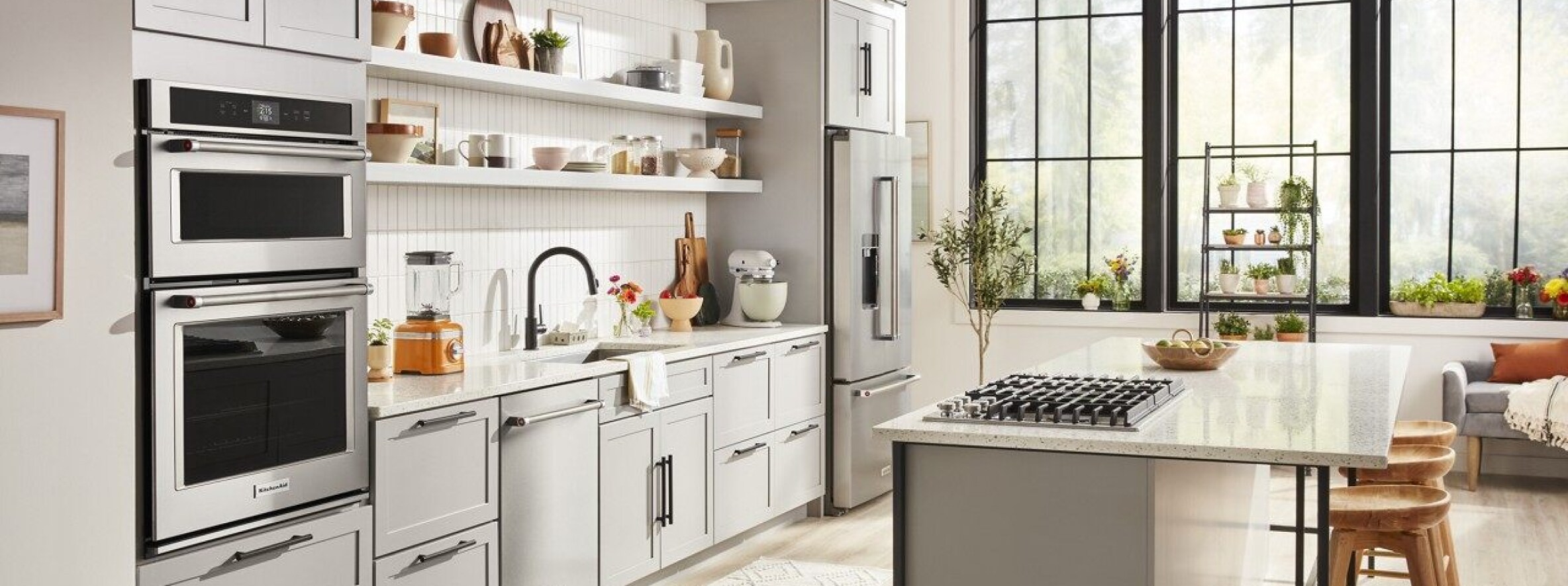 KitchenAid® appliances shown installed in a modern kitchen and bar area.