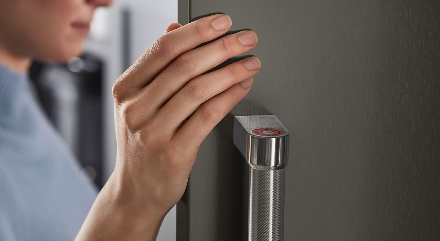 Close-up of a person opening the door of a refrigerator Close-up of a person opening the door of a refrigerator