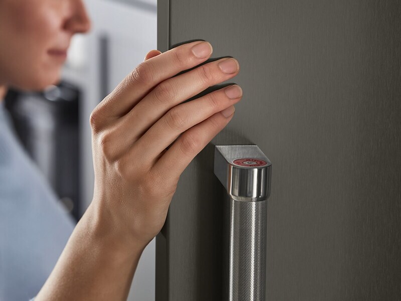 Close-up of a person opening the door of a refrigerator Close-up of a person opening the door of a refrigerator