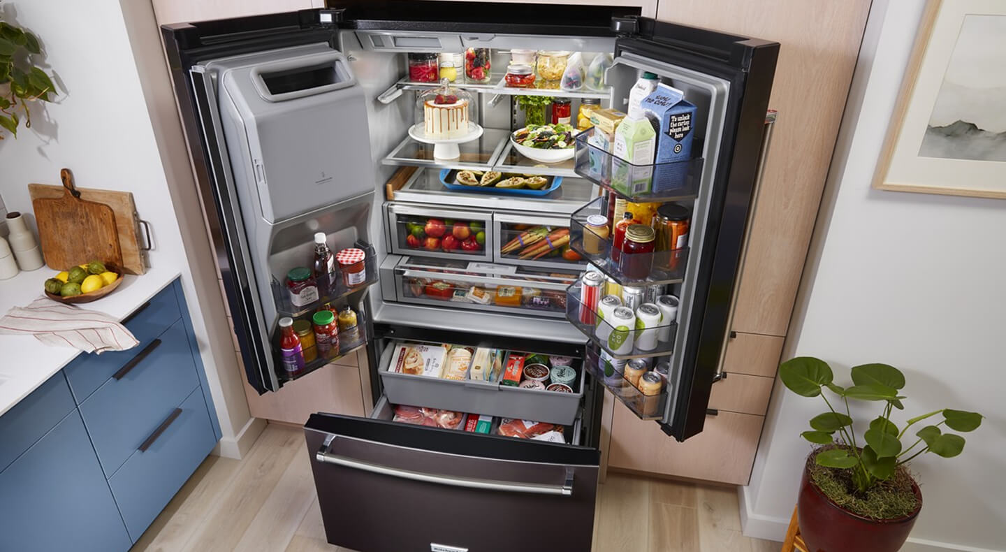 Bird’s-eye view of black stainless French door refrigerator stocked with food Bird’s-eye view of black stainless French door refrigerator stocked with food