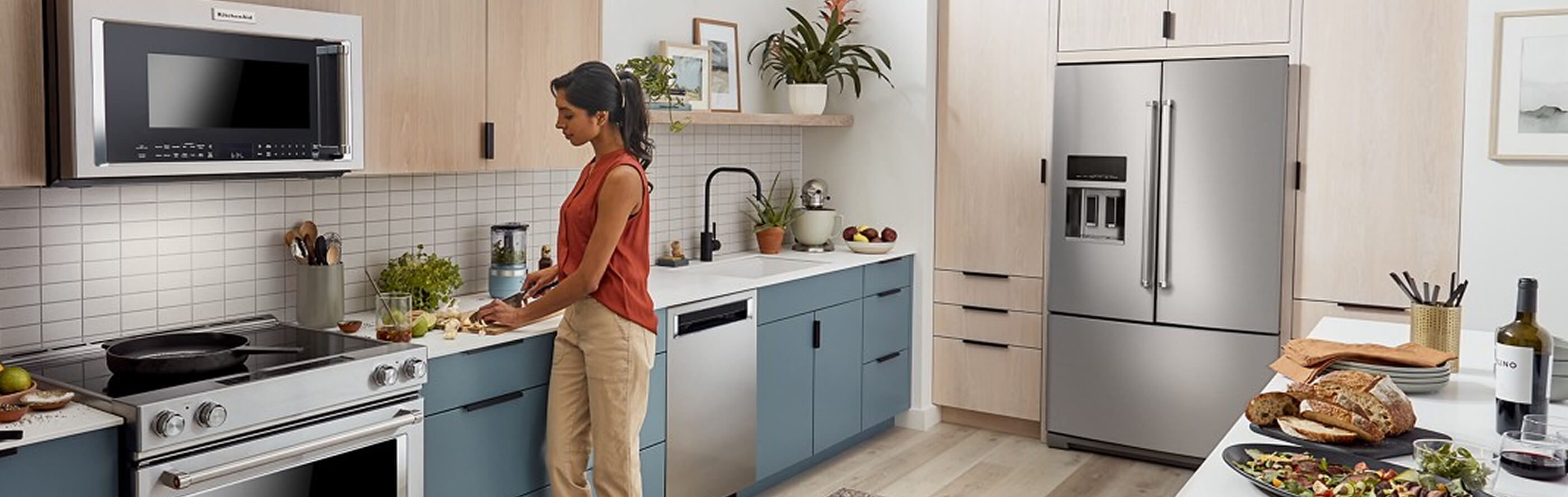 Kitchen with a KitchenAid® French door refrigerator built into light brown cabinetry