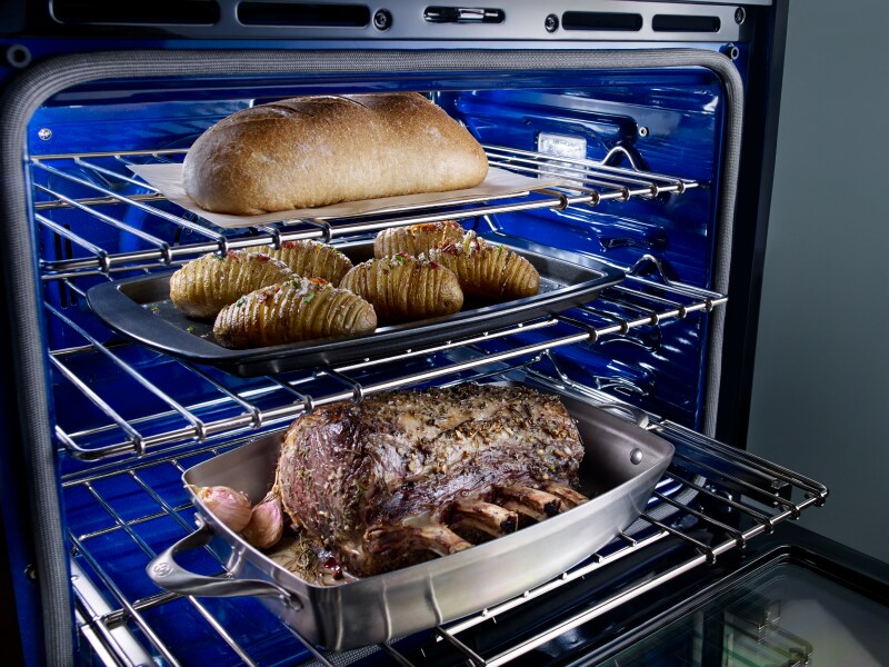 A rack with trays of baked goods and a loaf of bread A rack with trays of baked goods and a loaf of bread