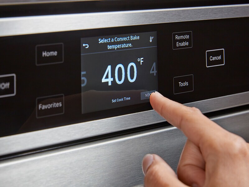 Someone operating their oven control panel