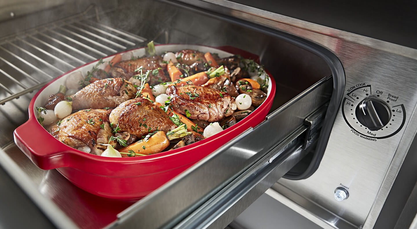 A roast and vegetables in a warming drawer