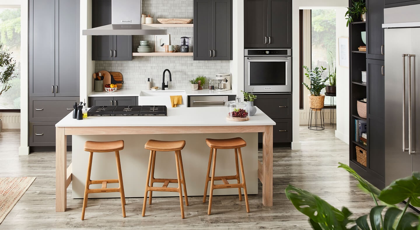 Kitchen island in front of sink and dishwasher next to wall oven 