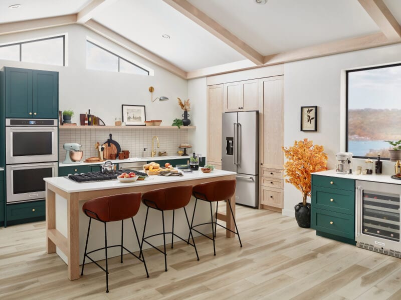 Kitchen with double oven, refrigerator and island with cooktop