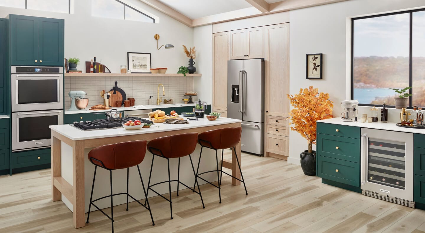 Kitchen with double oven, refrigerator and island with cooktop