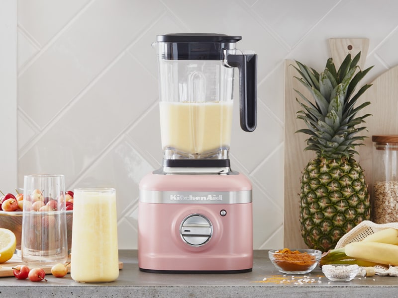 A KitchenAid® blender with a freshly made smoothie on a modern kitchen counter. A KitchenAid® blender with a freshly made smoothie on a modern kitchen counter.