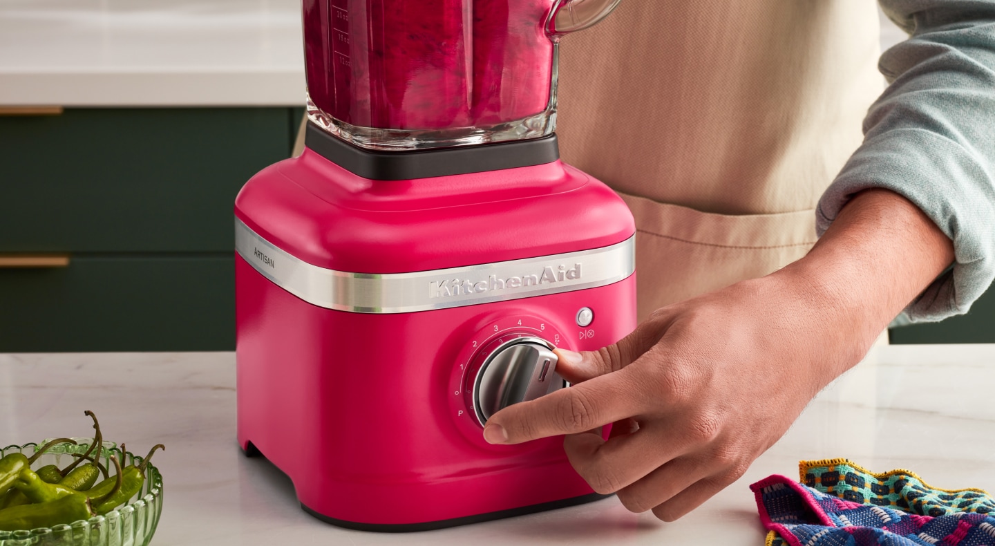 A person programming a blender setting on a KitchenAid® blender. A person programming a blender setting on a KitchenAid® blender.