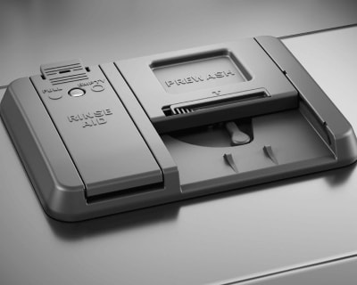 Closed dishwasher detergent dispenser with a slot for prewash and rinse aid