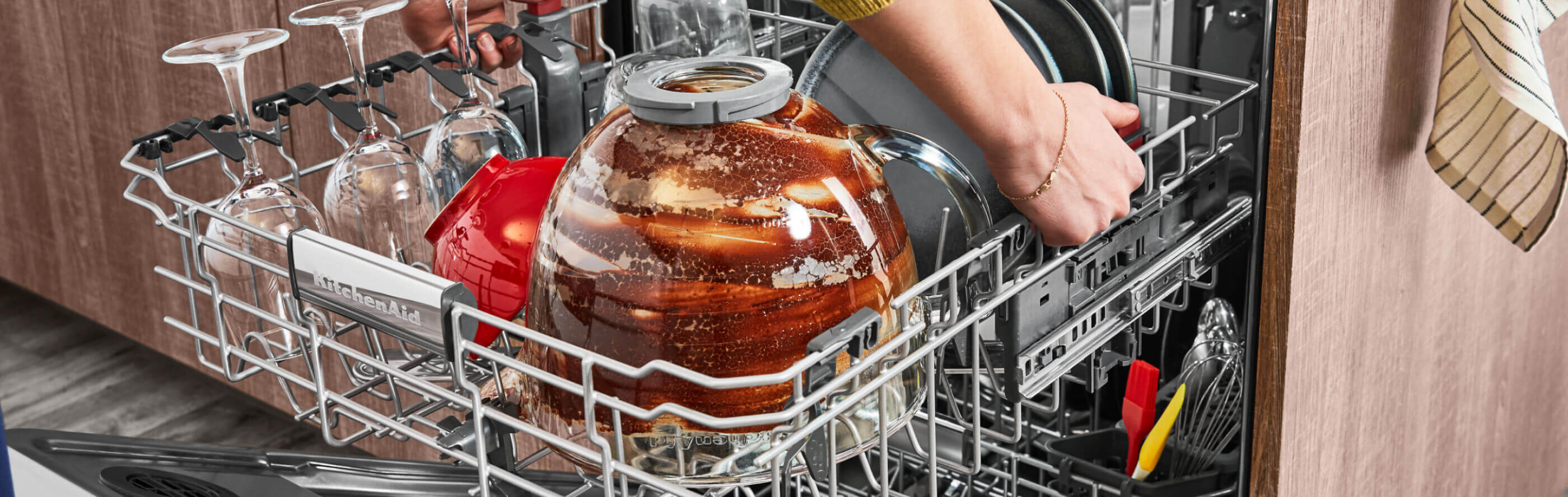 Dirty wine glasses and mixing bowl in the top rack of a dishwasher