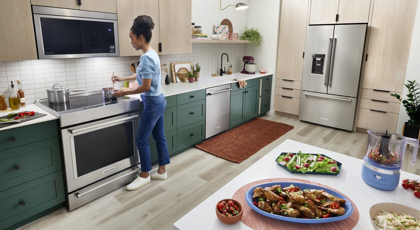 Person making chicken wings and an assortment of vegetables Person making chicken wings and an assortment of vegetables