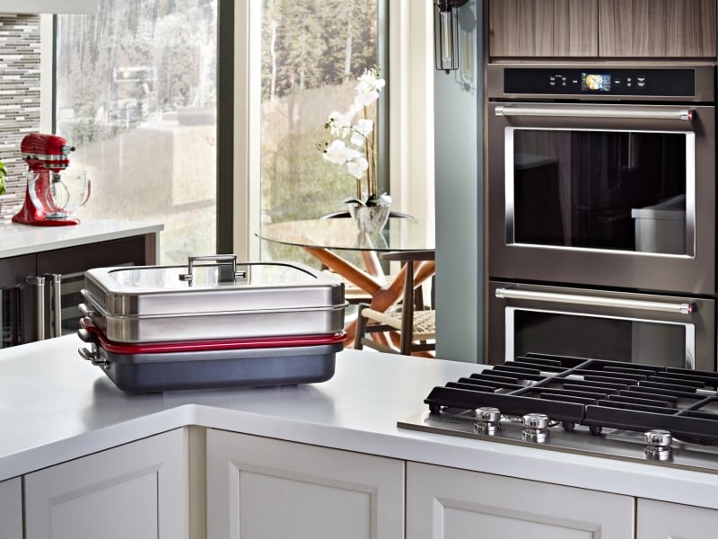A covered baking stone in front of a double wall oven  A covered baking stone in front of a double wall oven