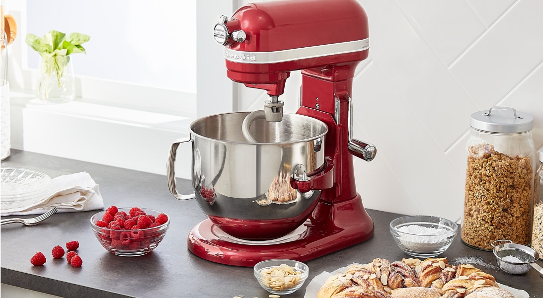 Berries, bread and jars of granola next to a KitchenAid® stand mixer.