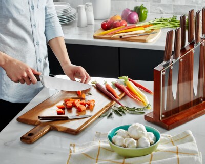 Person chopping carrots on cutting board