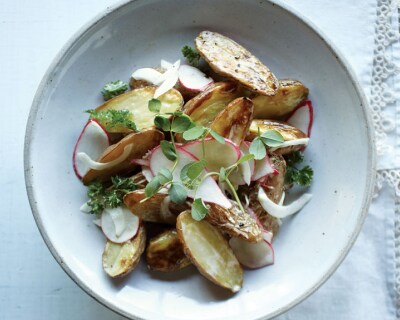 Roasted potatoes garnished with herbs in a bowl
