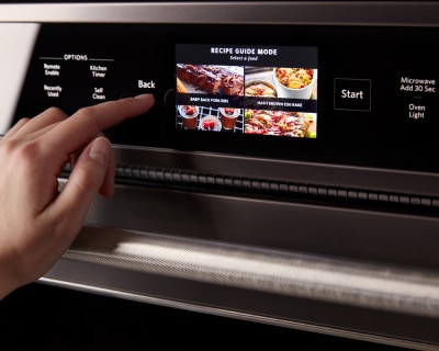 Person selecting settings on the digital display of an oven