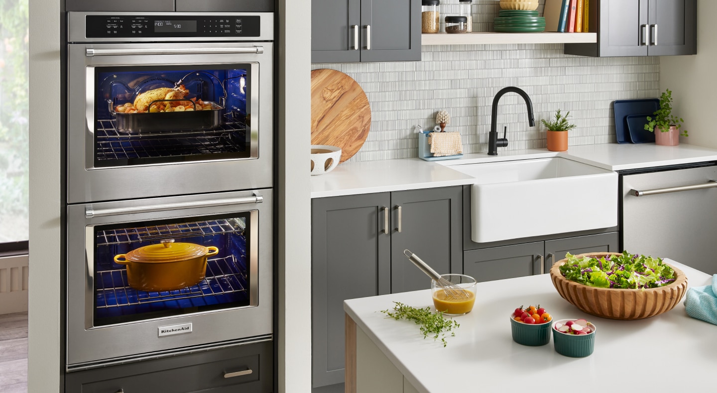 Double wall oven with a whole turkey and dutch oven cooking inside the compartments