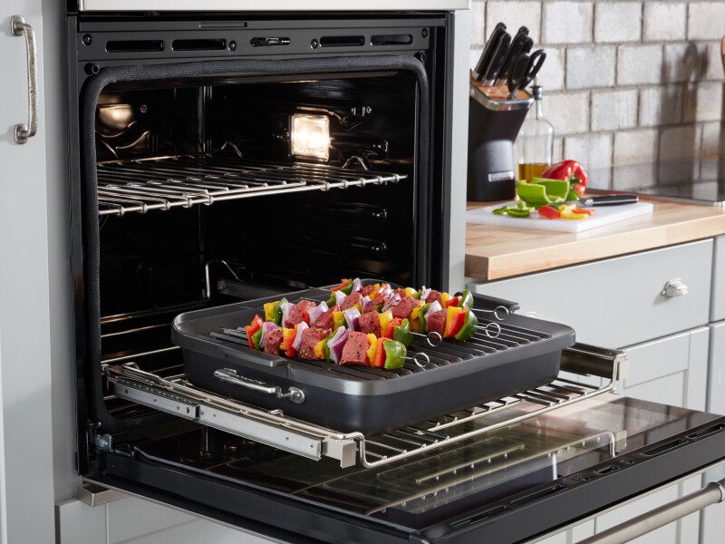 An oven light bulb illuminating an open oven 
