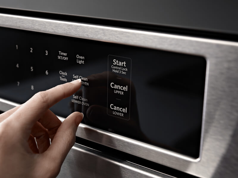 Person selecting a setting on an oven control panel