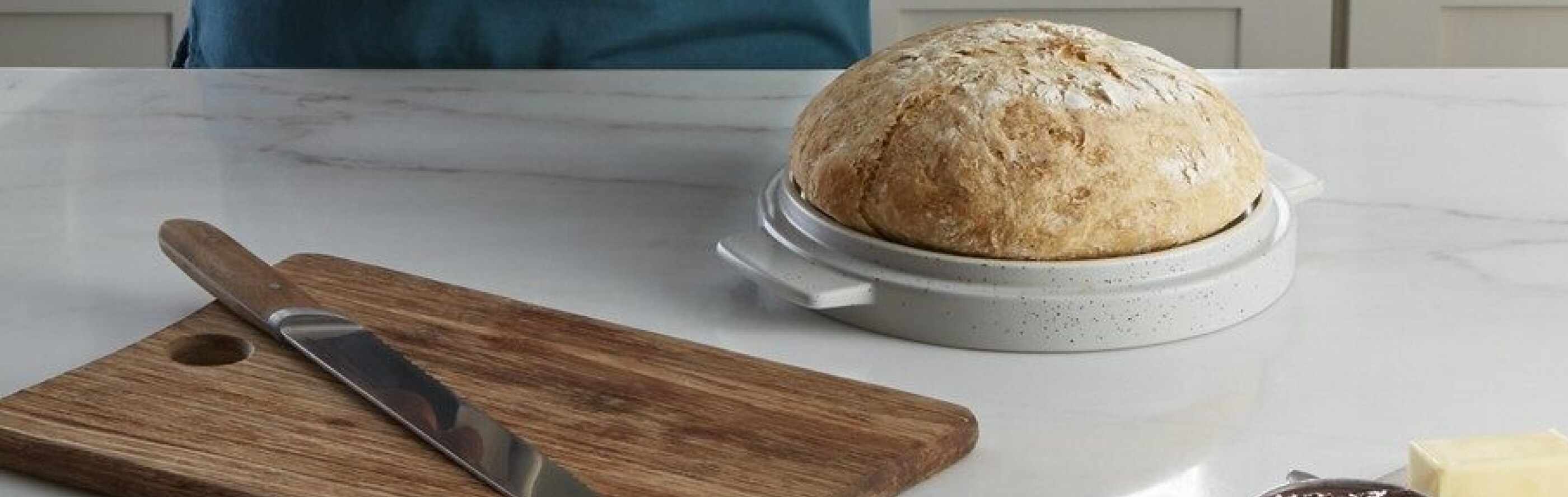 Loaf of bread next to a wooden cutting board and knife