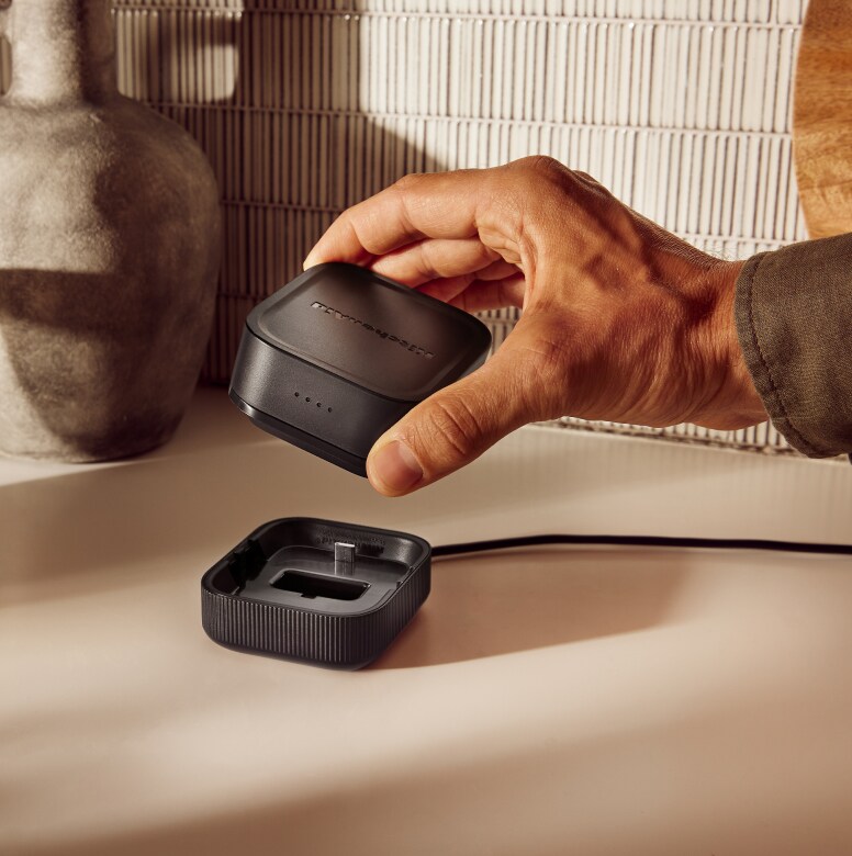 A person removing a KitchenAid Go™ Rechargeable battery from its dock.