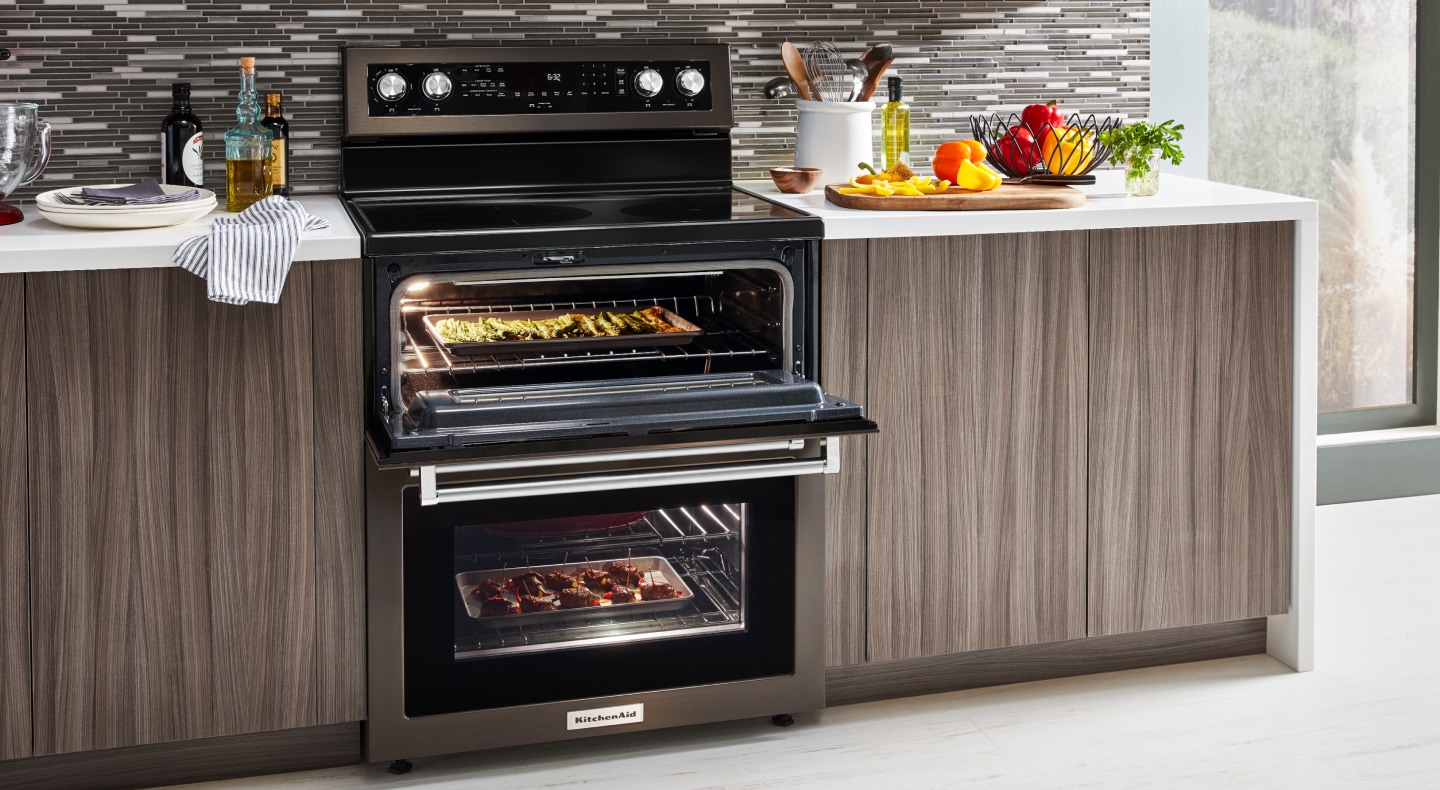 A slide-in double oven range with various dishes cooking inside A slide-in double oven range with various dishes cooking inside