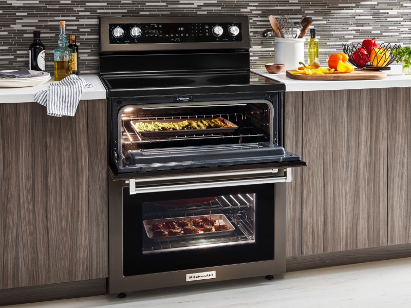 A slide-in double oven range with various dishes cooking inside A slide-in double oven range with various dishes cooking inside