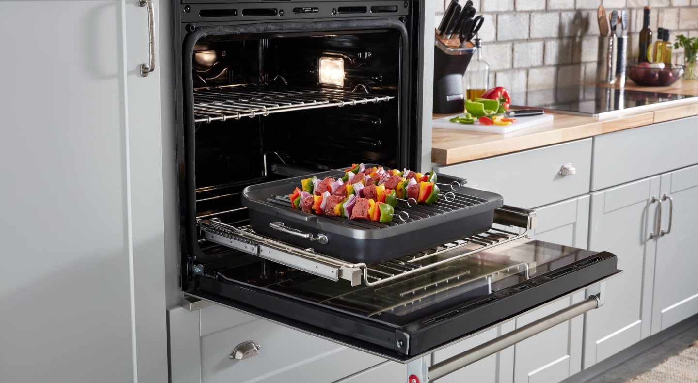 An open wall oven with freshly baked kebabs inside An open wall oven with freshly baked kebabs inside