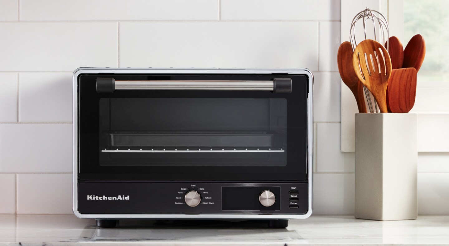 A KitchenAid® countertop oven with air fry on a modern kitchen counter.  A KitchenAid® countertop oven with air fry on a modern kitchen counter.