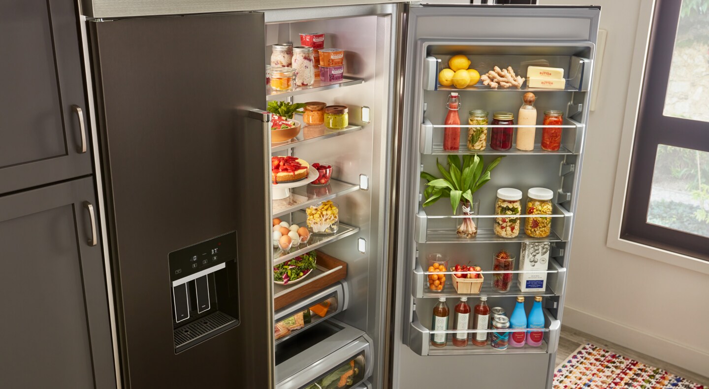 An open refrigerator door where food items are being stored An open refrigerator door where food items are being stored