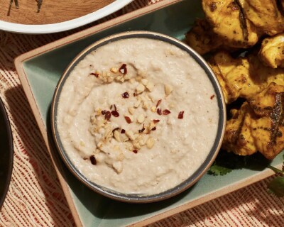 A bowl of peanut sauce with chopped nuts on top
