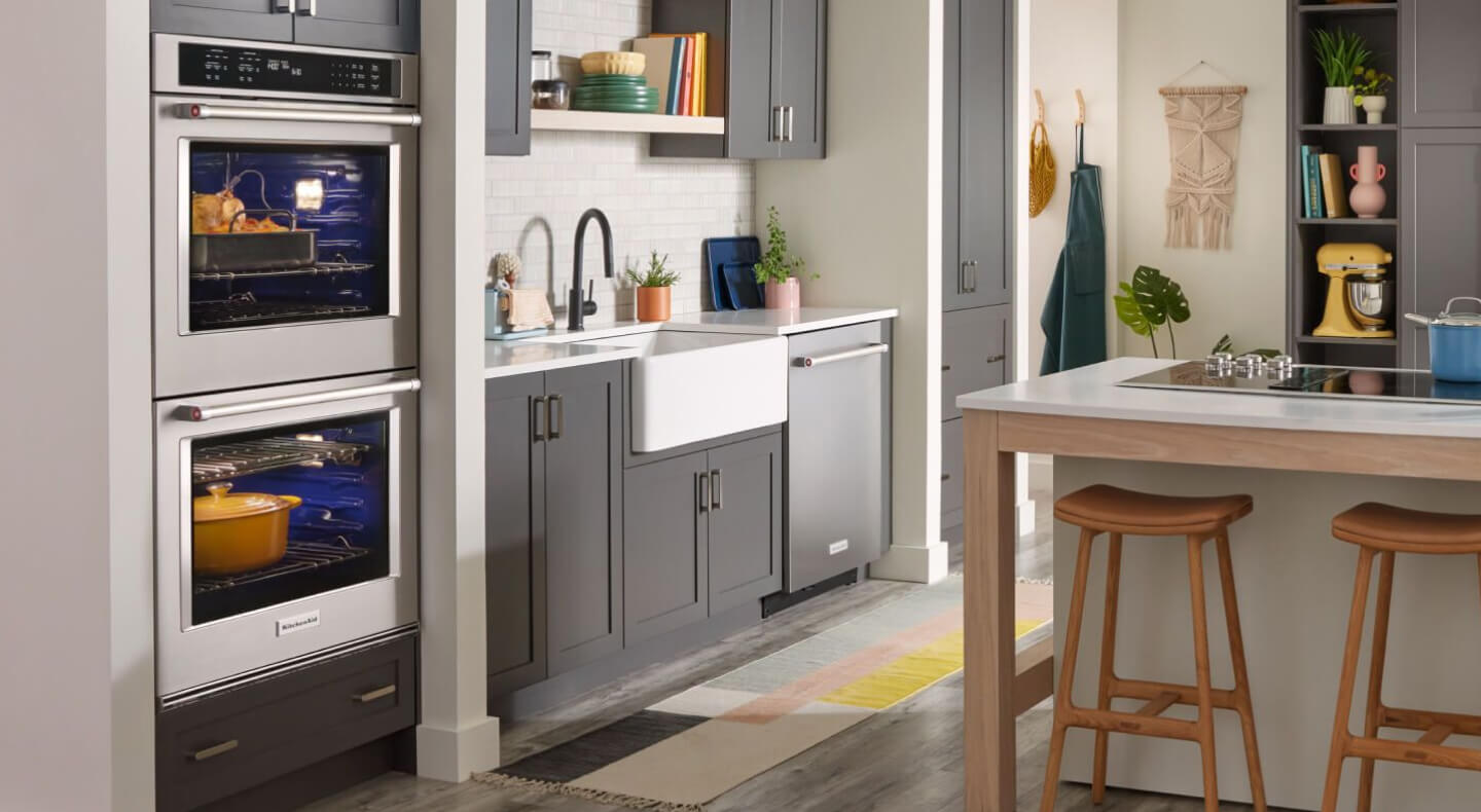 A clean, modern kitchen with black cabinetry and a KitchenAid® double wall oven in the foreground