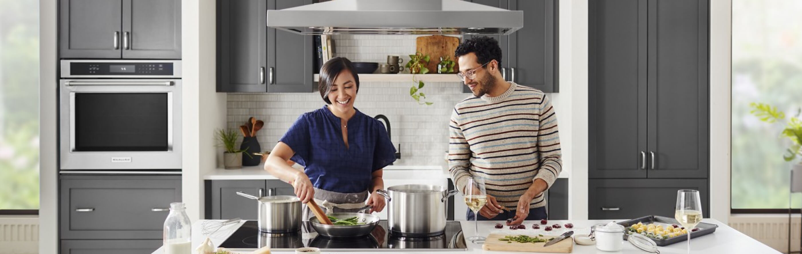 Two people cooking at an island