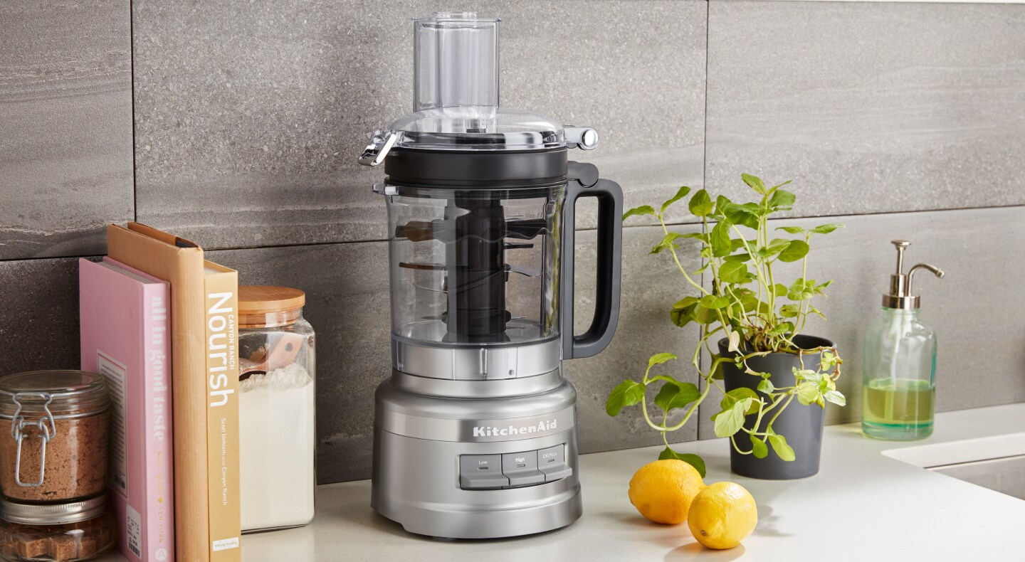 Large silver food processor on the counter with lemons Large silver food processor on the counter with lemons