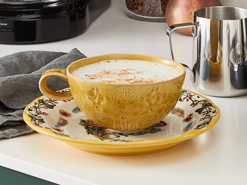 Homemade latte in a yellow coffee cup