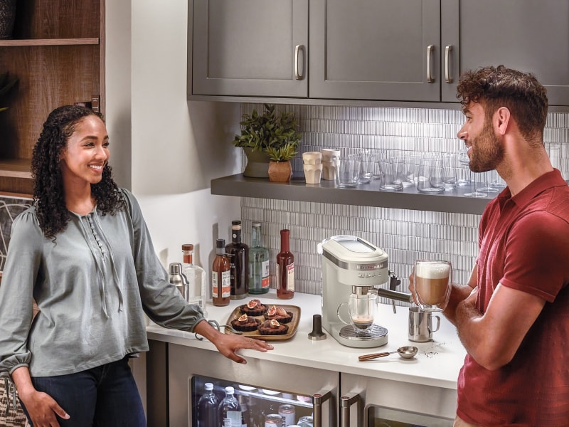 Couple standing at a kitchen coffee bar drinking lattes Couple standing at a kitchen coffee bar drinking lattes