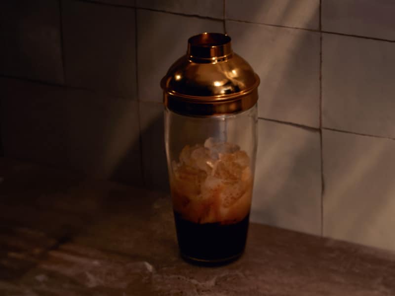 Espresso martini ingredients in a glass cocktail shaker
