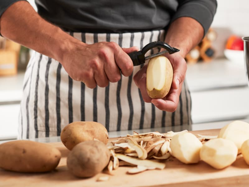 A man peeling potatoes.