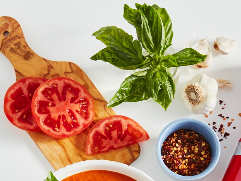 Bruschetta ingredients on a cutting board on a counter.