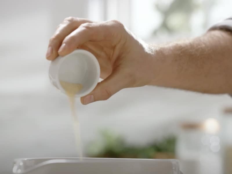 Person pouring seasonings from a small bowl