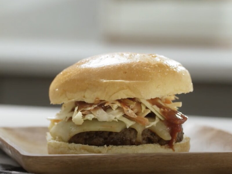 Cooked burger on a bun topped with coleslaw