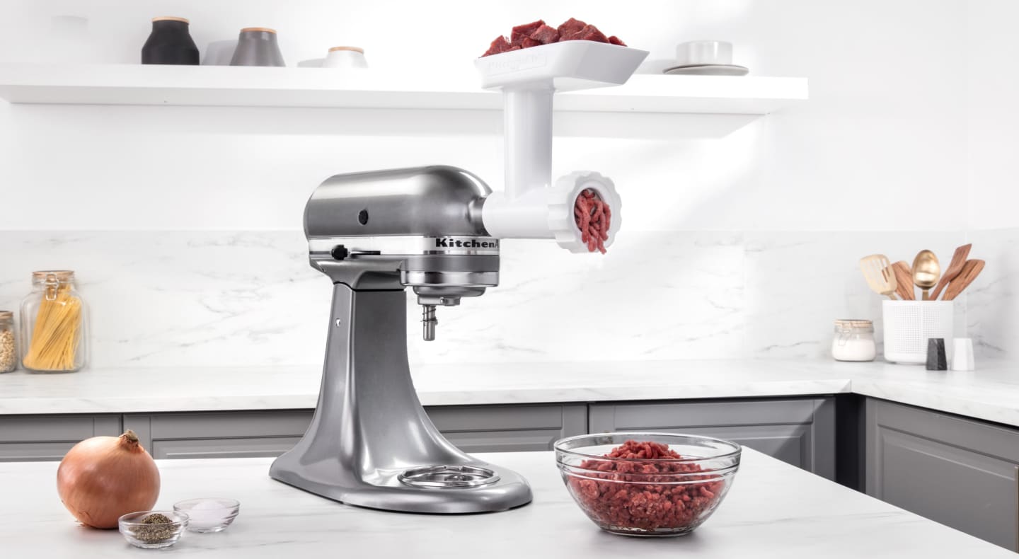 Silver KitchenAid® stand mixer with Meat Grinder Attachment grinding beef Silver KitchenAid® stand mixer with Meat Grinder Attachment grinding beef