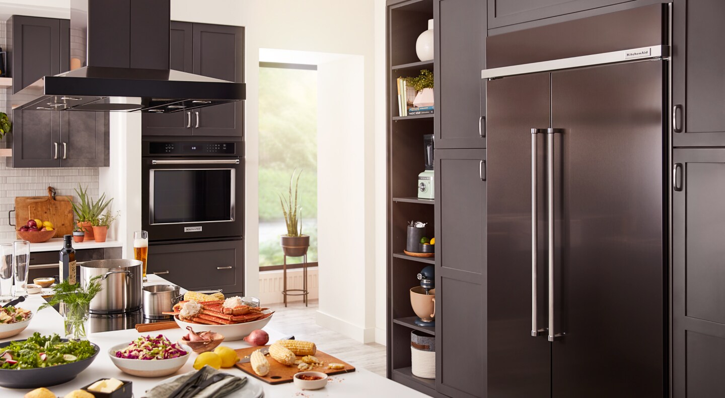 Full view of kitchen with countertop, plates of food and panel-ready appliances Full view of kitchen with countertop, plates of food and panel-ready appliances