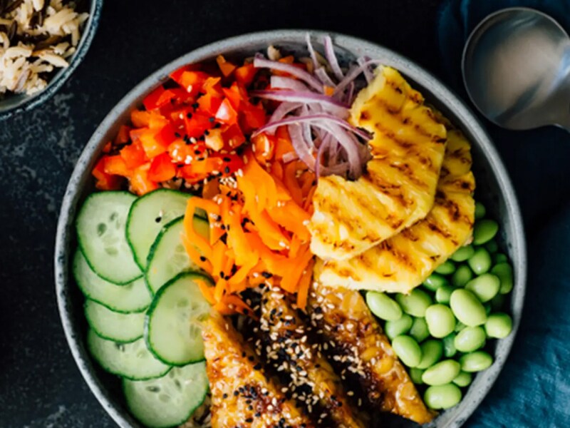 Birds-eye view of a poke bowl with red onion, tomato, cucumber and more Birds-eye view of a poke bowl with red onion, tomato, cucumber and more