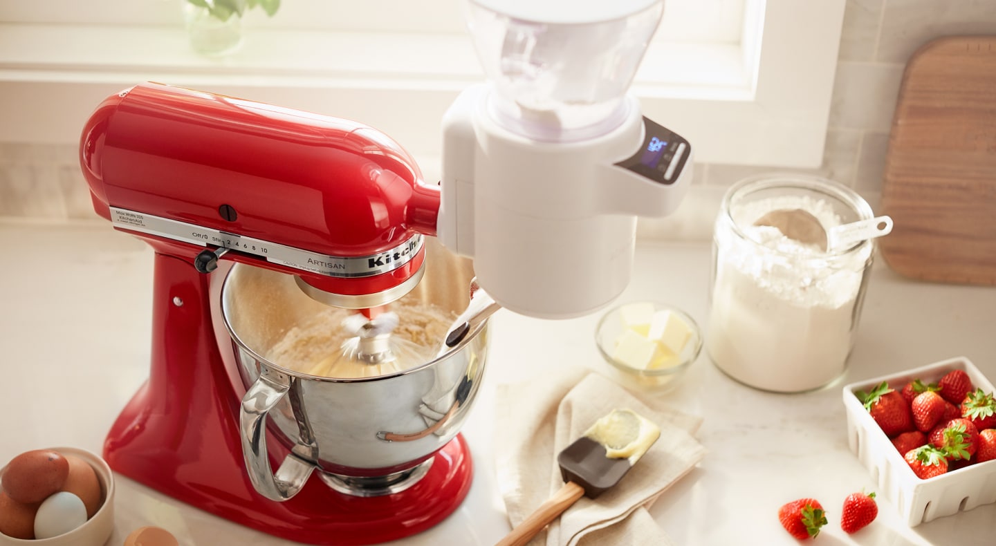 A red KitchenAid® stand mixer amongst various baking ingredients A red KitchenAid® stand mixer amongst various baking ingredients