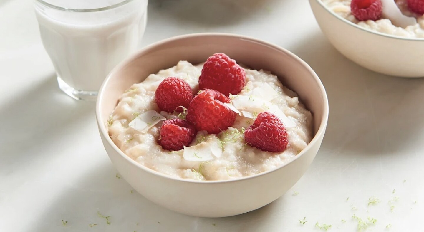 A bowl of rice pudding topped with raspberries A bowl of rice pudding topped with raspberries